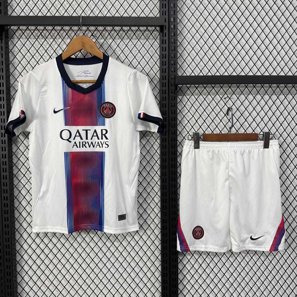 Biely detský hosťovský set Paris Saint-Germain 26/27 s červeno-modrým pruhom. Dres a šortky v balení, priedušný materiál a moderný dizajn.