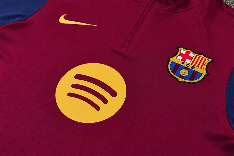 Detail klubového znaku a krátkeho zipsu na bordovom vrchnom diele FC Barcelona