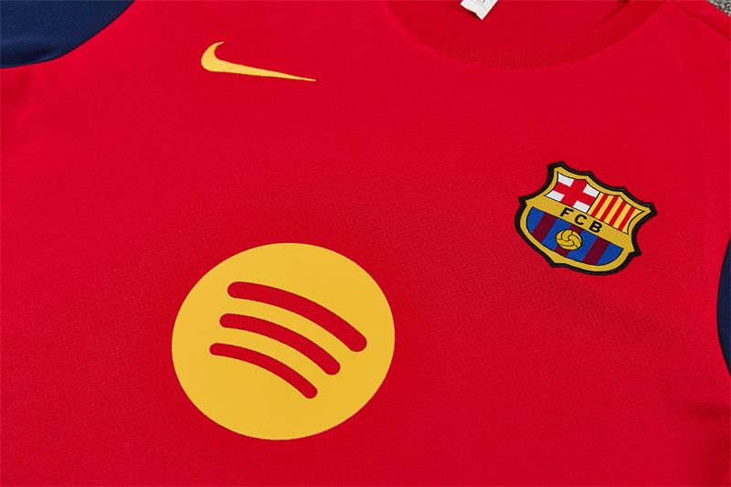Detail klubového znaku a žltých prvkov na hrudi červeného dresu FC Barcelona 2026/27