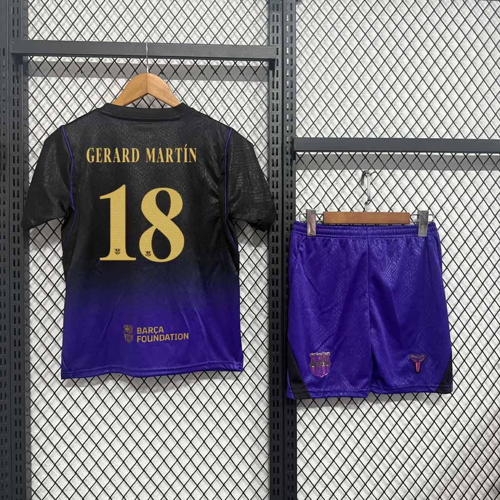 Zadná strana detského hosťovského dresu Barcelona 26/27 so zlatou potlačou GERARD MARTÍN a číslom 18, vedľa fialové šortky