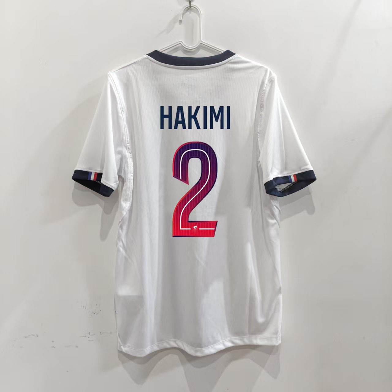 Zadná strana bieleho hosťovského dresu Paris 26/27 s potlačou HAKIMI 2
