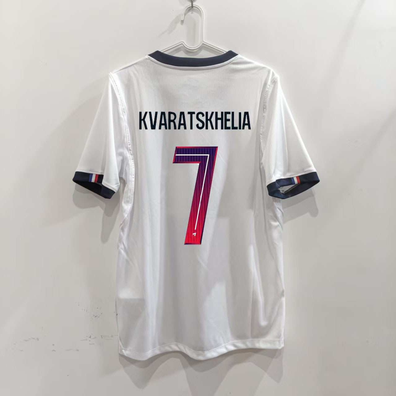 Zadná strana bieleho hosťovského dresu Paris 26/27 s potlačou KVARATSKHELIA 7