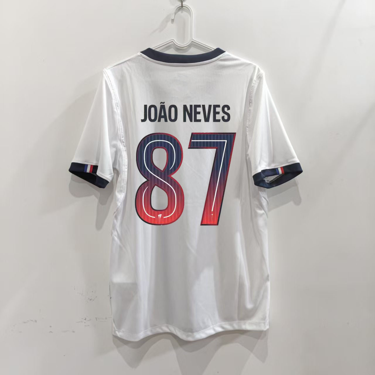 Zadná strana bieleho hosťovského dresu Paris 26/27 s potlačou JOÃO NEVES 87